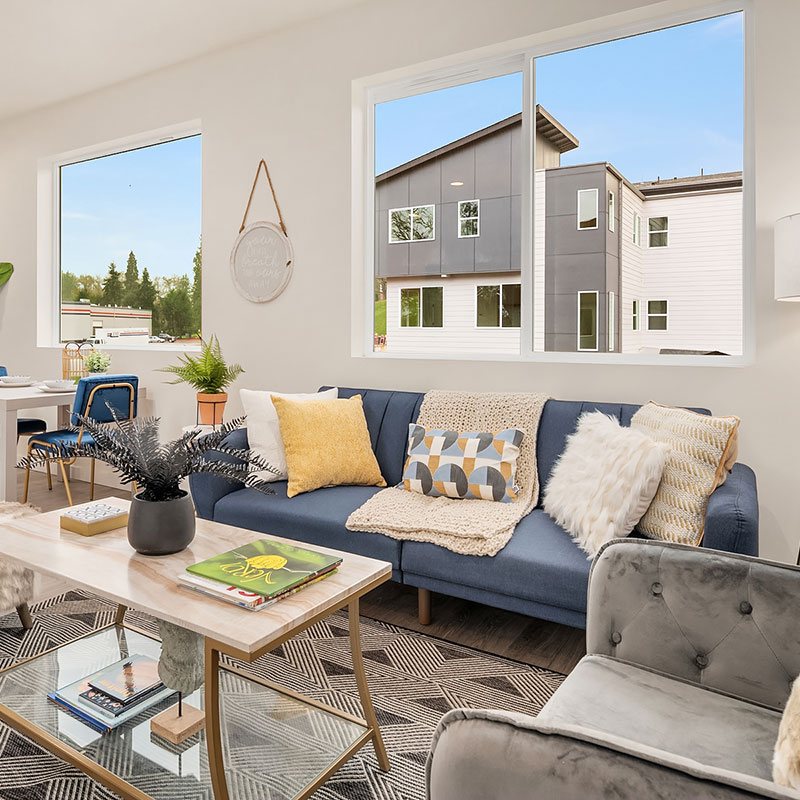 Bright living room with blue sofa, coffee table and large windows