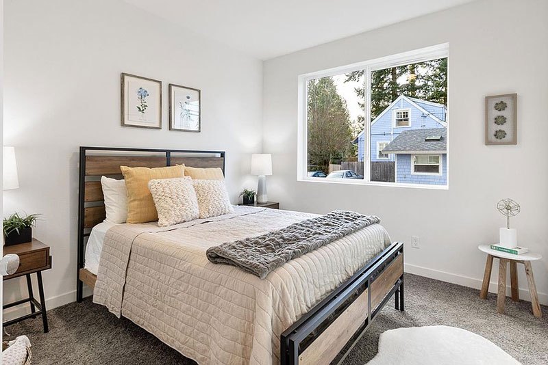 Furnished bedroom with queen bed and large window